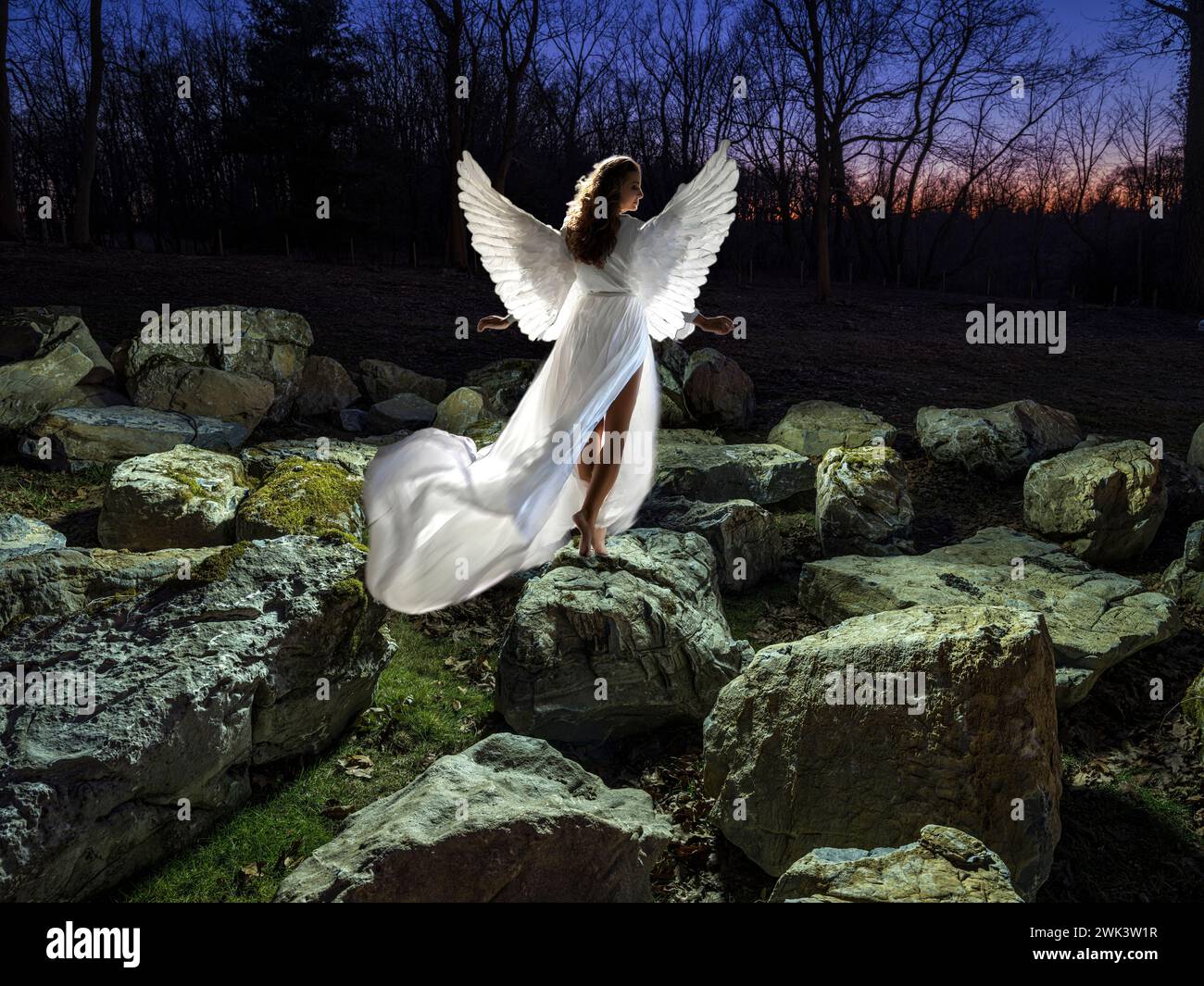 Heavenly angel in rocky field with dramatic lighting Stock Photo