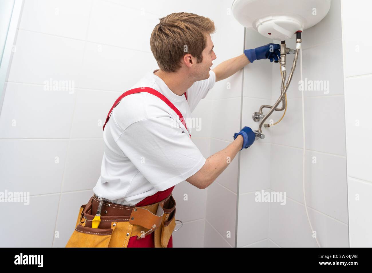 Professional plumber checking a boiler and pipes, boiler service concept. Stock Photo