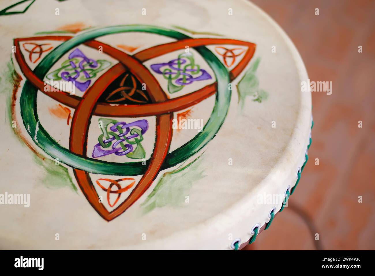 painting of Celtic symbol drawn on percussion instrument skin - triskle Stock Photo