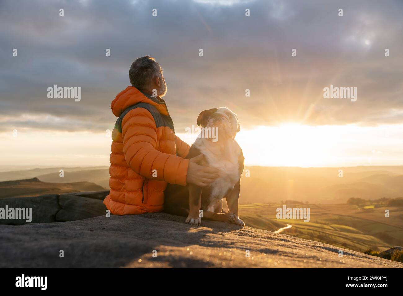 old mature man hiking in mountains with his dog, exercise and fitness for wellness, healthy lifestyle and smile. Face of a senior mature gentleman wit Stock Photo