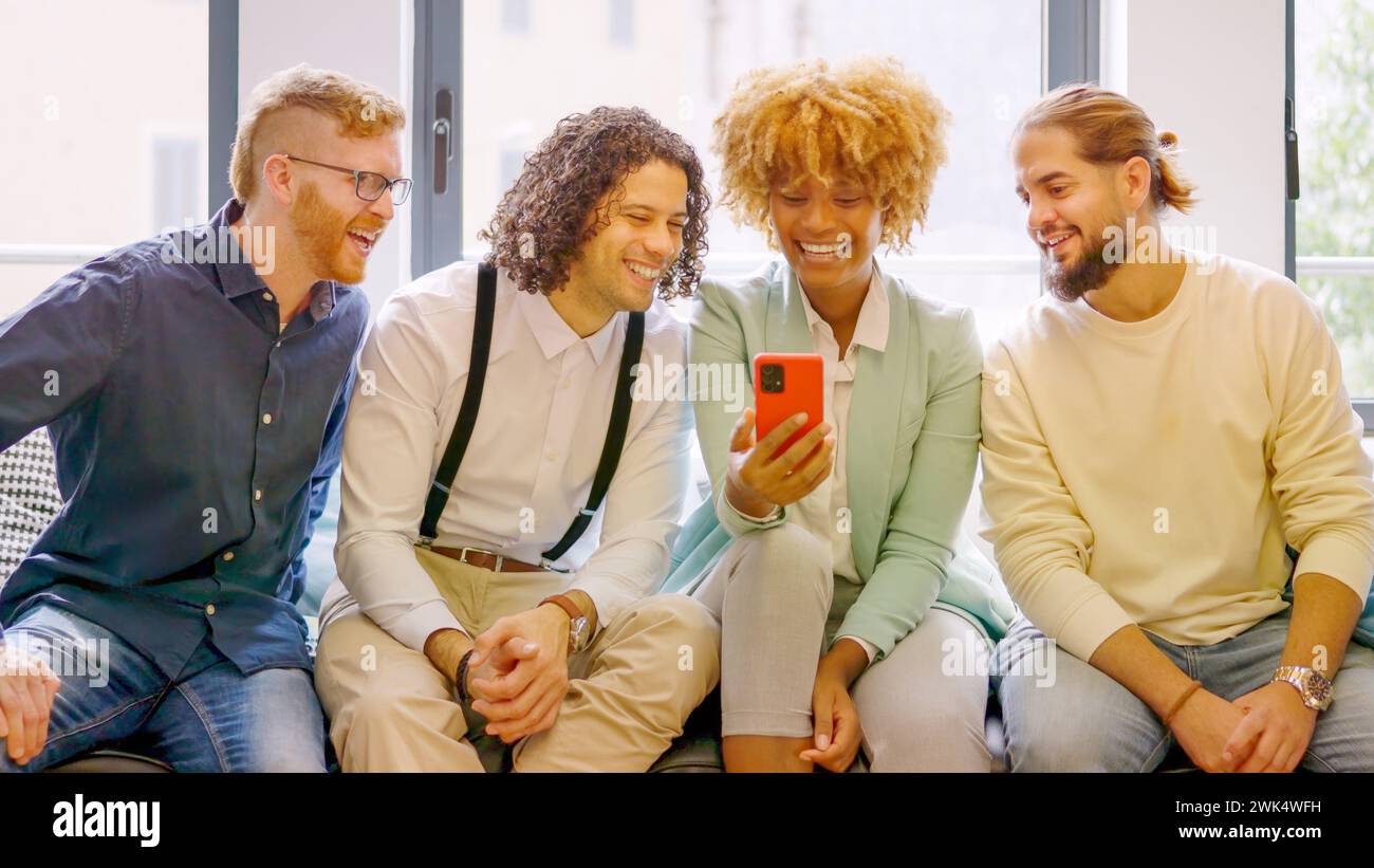 Coworkers using phone sitting relaxed during a break Stock Photo