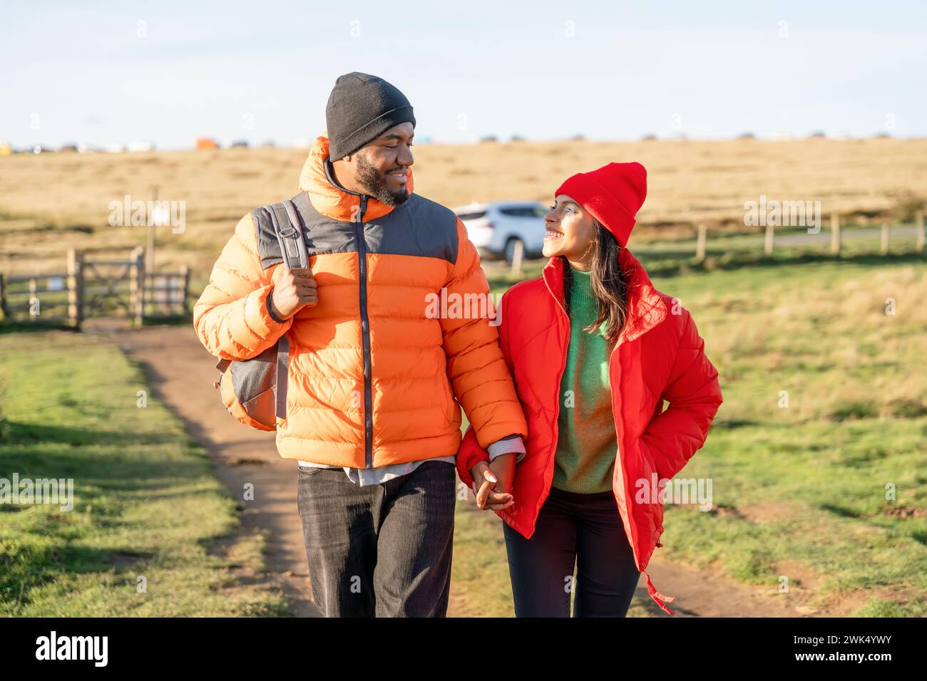 Portrait of happy couple in love walking along countryside at the sunset.  Love, hiking and active lifestyle concept Stock Photo