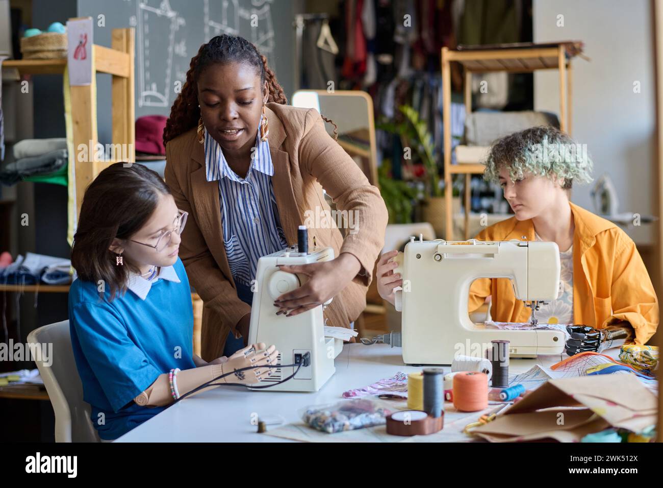 Portrait of Black young woman teaching girl with disability using