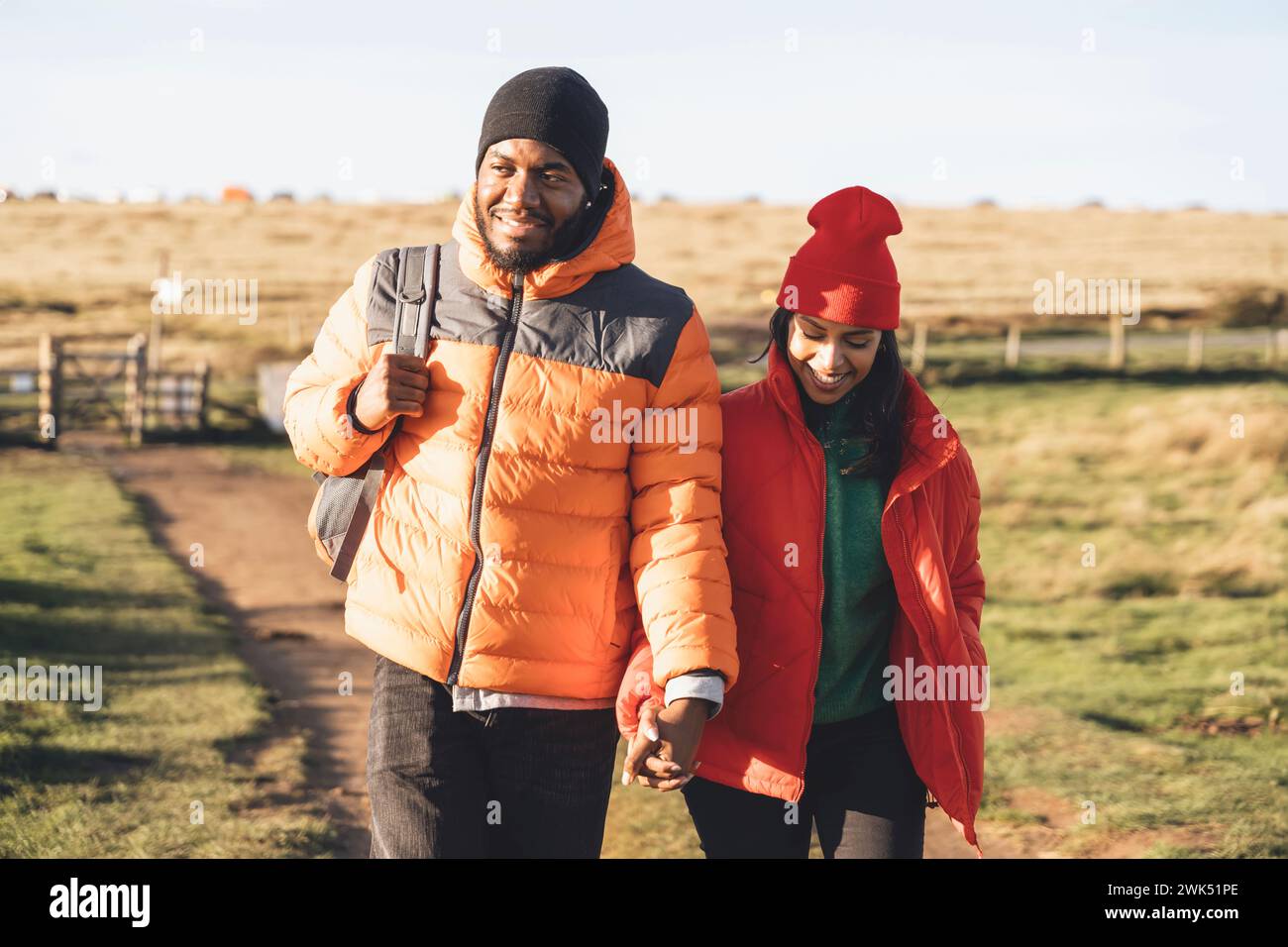 Portrait of happy couple in love walking along countryside at the sunset.  Love, hiking and active lifestyle concept toned image Stock Photo