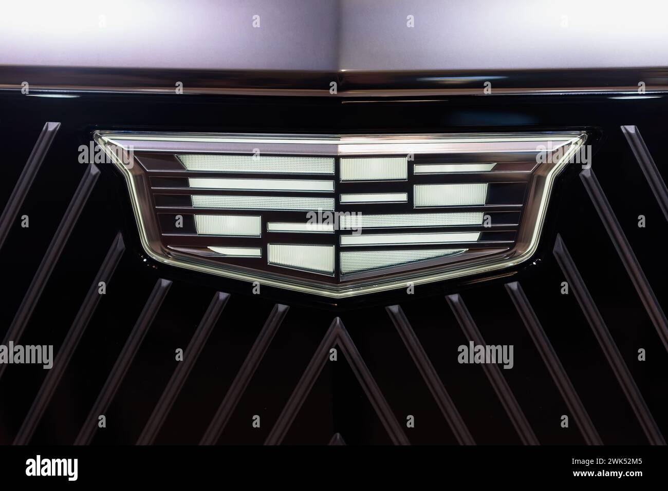 Design of the front of a black EV Cadillac car. Grille and logo symbol with LED lights. Stock Photo