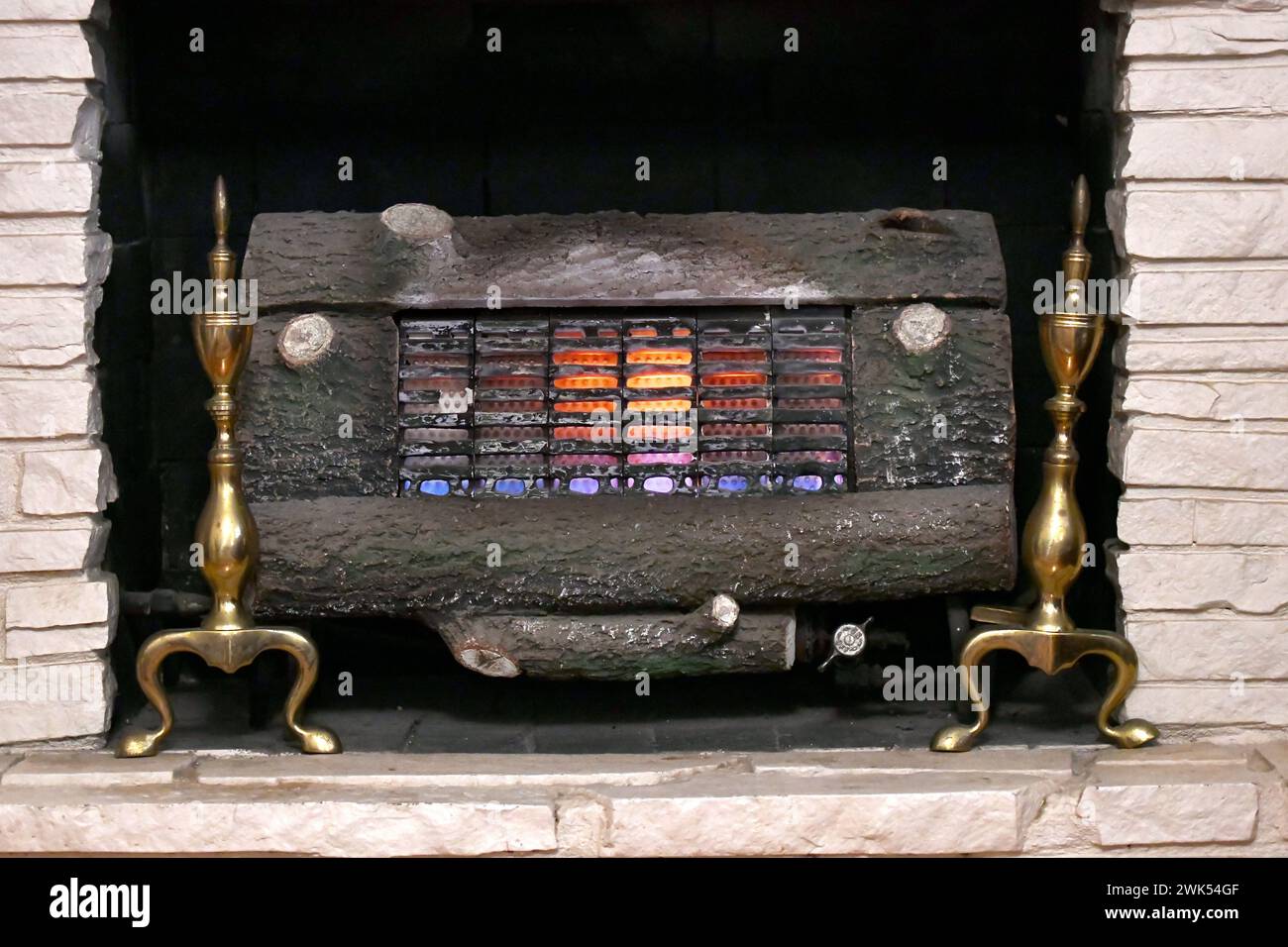 Fireplace has vintage gas log insert. Heater is on and flames have