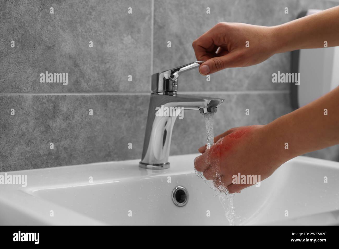 Woman holding burned hand under cold water indoors, closeup. Space for text Stock Photo Alamy