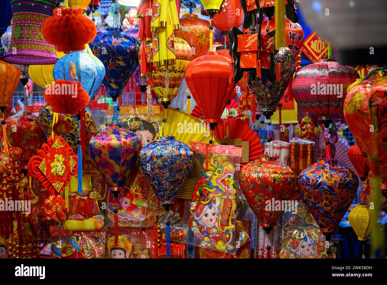 Buying brightly colored decorations for Tet Celebrations at the Hanoi Tet Night Market, Hanoi, Vietnam Stock Photo