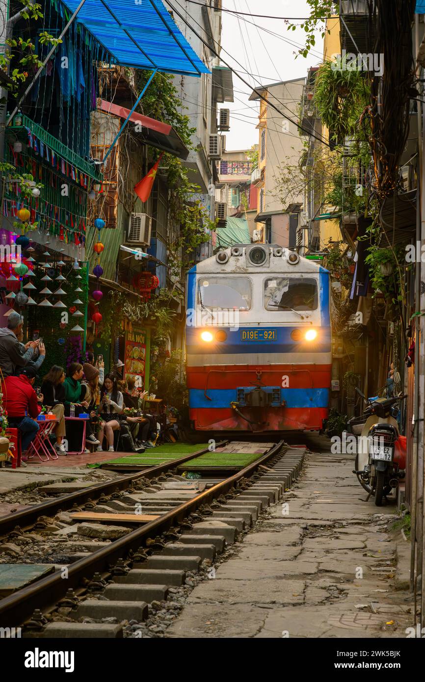 An approaching Vietnamese railway train on Train Street, Hanoi, Vietnam Stock Photo