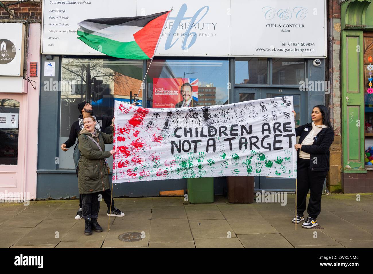 Wakefield, UK. 18 FEB, 2024. During Wakefields first Palestine march protestors gather outside the office of Simon Lightwood, Labour MP for Wakefield. pro palestine demonstrators held banners reading Children are not a target. Lightwood and/or his team were not present and the demonstrators were moved on by police after a couple of minutes. Credit Milo Chandler/Alamy Live News Stock Photo