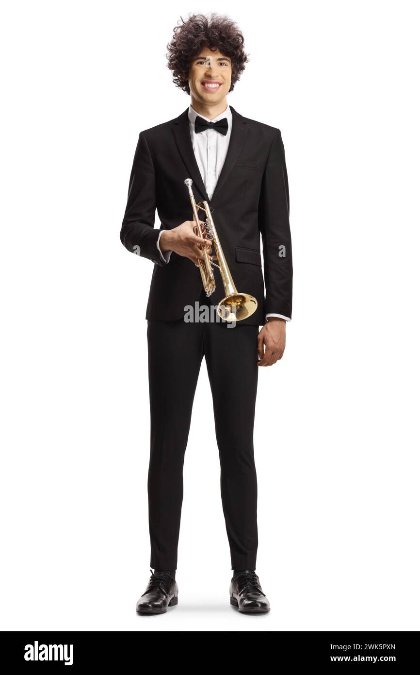 Elegant young man in a black suit holding a trumpet and smiling isolated on white background Stock Photo