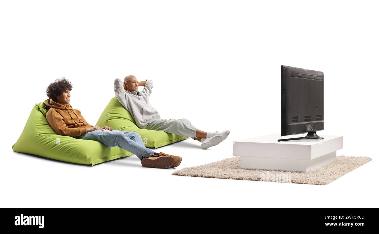 Young men sitting on beanbags and watching tv in a modern living room Stock Photo