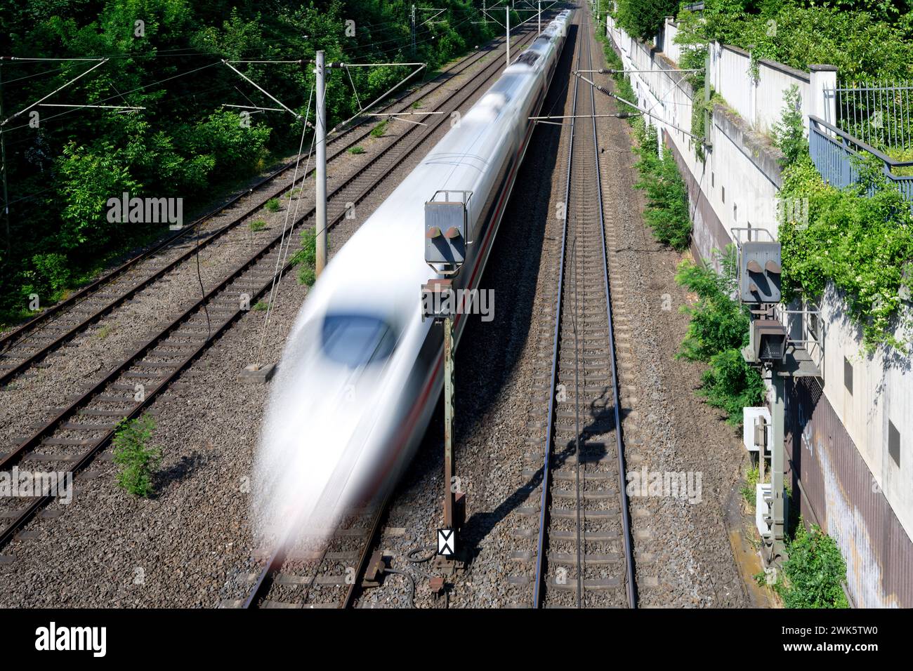 view from a bridge onto a fast train in motion blur on a four-track line in germany Stock Photo