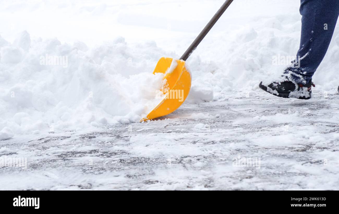 Man shoveling snow off of his driveway after a winter storm in Canada. Man with snow shovel cleans sidewalks in winter. Winter time. Stock Photo