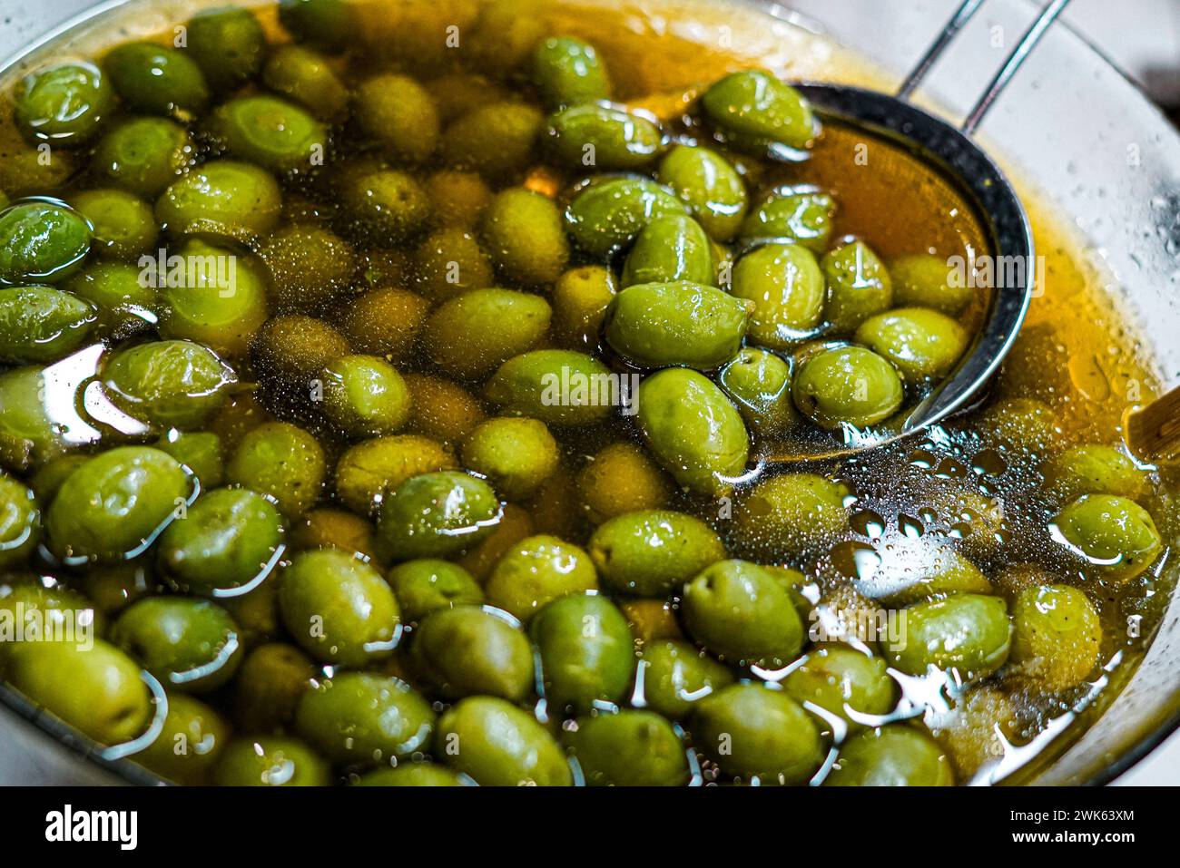 Green olives in a silver bowl. Stock Photo
