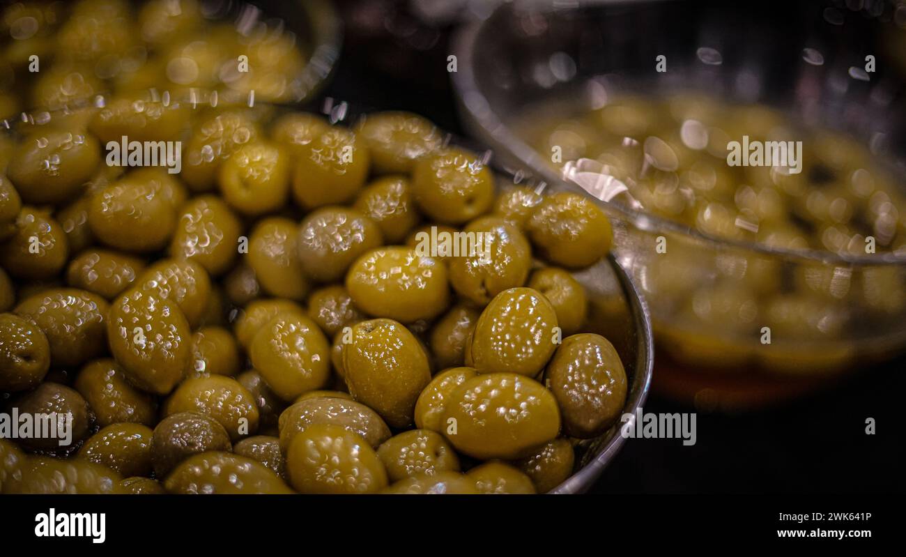 Green olives in a silver bowl. Stock Photo