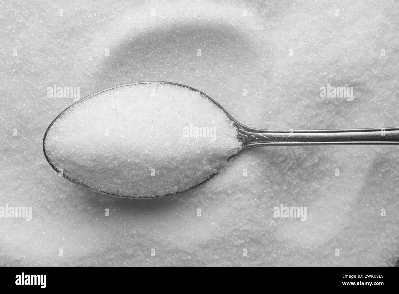 Metal spoon on granulated sugar, top view Stock Photo