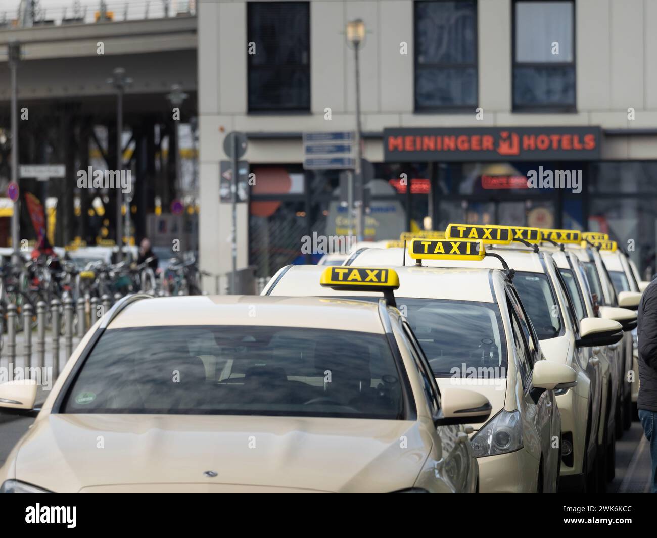 Taxi signs on beige cars waiting in a row in Berlin. The yellow symbol ...