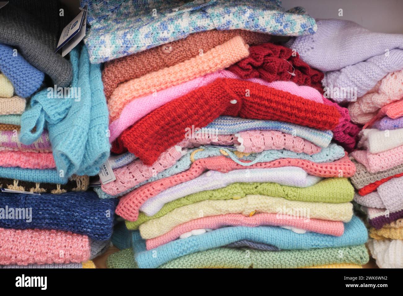 Bunch of knitted warm sweaters with different knitting patterns. Stock Photo