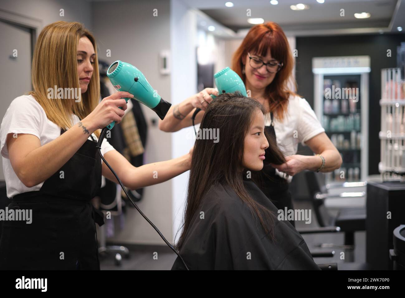 Hairdressers drying the hair of a woman at the salon Stock Photo