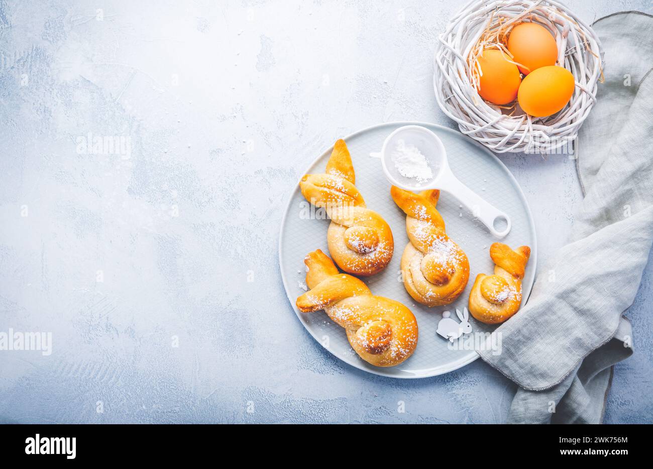 Buns made from yeast dough in a shape of Easter bunny and colored eggs Stock Photo