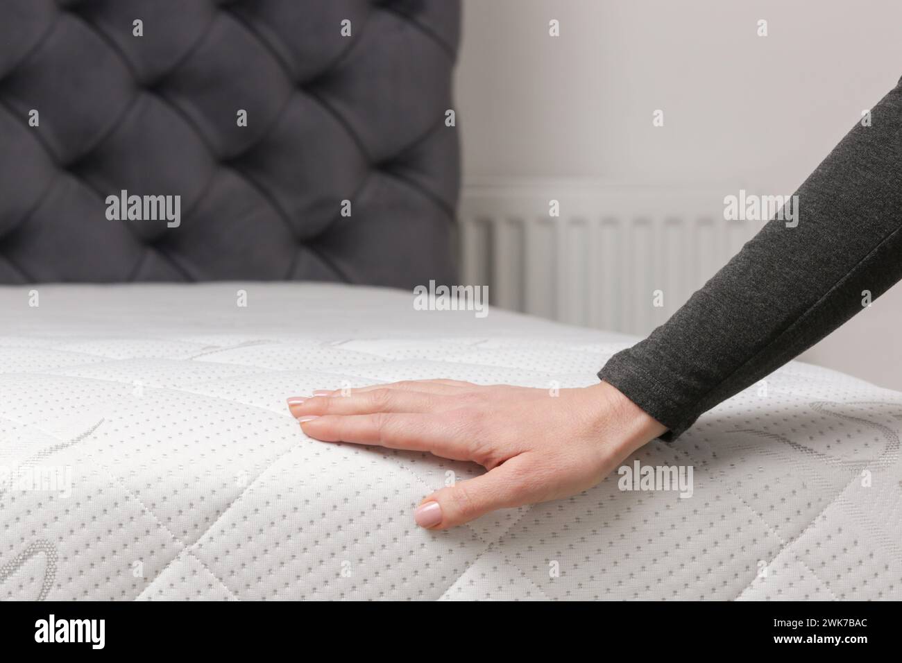Woman press on comfortable mattress, checking and testing quality Stock Photo
