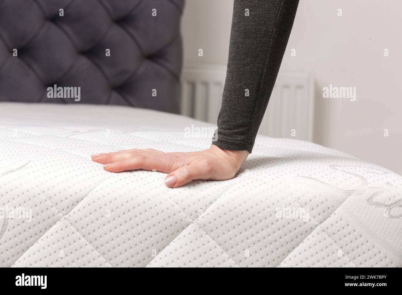 Woman press on comfortable mattress, checking and testing quality Stock Photo