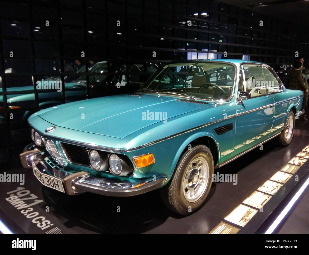 Blue and green BMW parked alongside other cars in a spacious room Stock ...