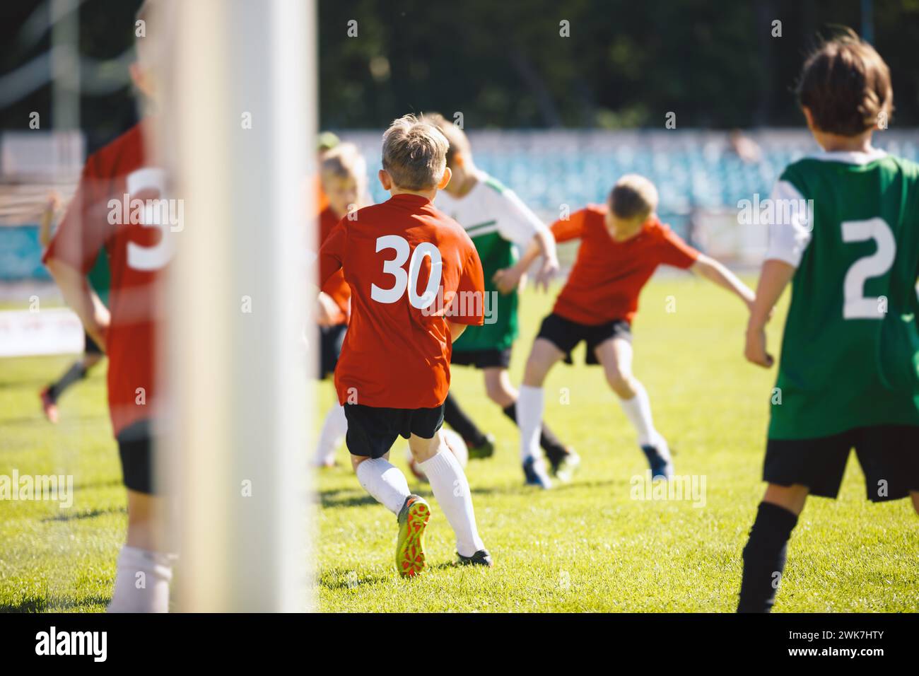Group of School Boys Play Soccer Football Match With Friends. Youth Professionals Soccer Kids Kicking Ball on Grass Pitch. CHildren in Red an Green Je Stock Photo