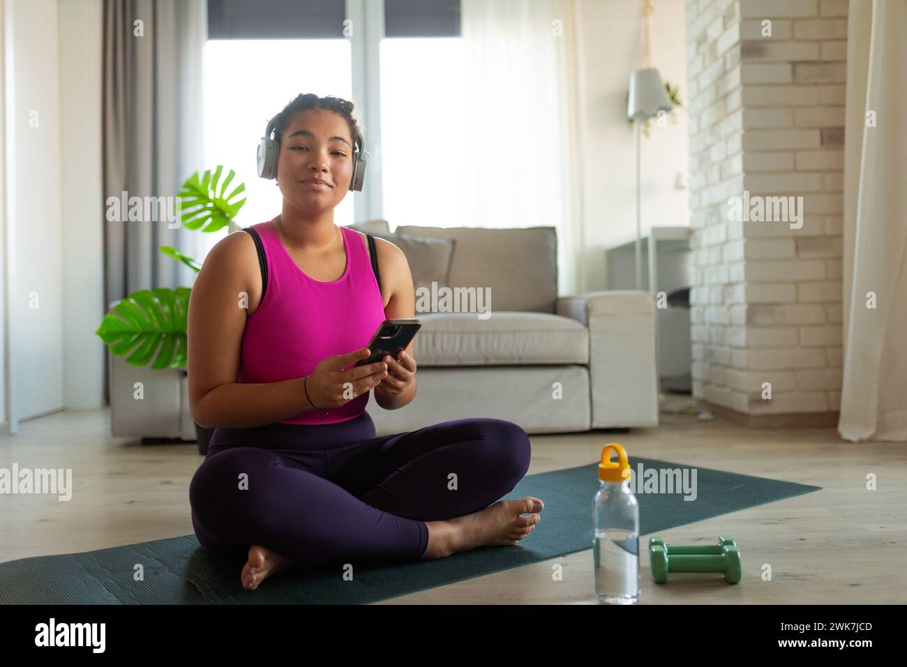 Woman resting after home workout, New Year's resolutions, healthy lifestyle, losing weight and selfcare. Concept of morning or evening workout routine Stock Photo