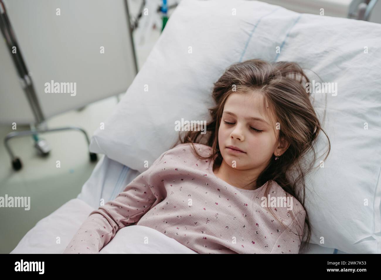 Little girl patient lying in hospital bed. Children in intensive care unit in hospital sleeping. Banner with copy space. Stock Photo