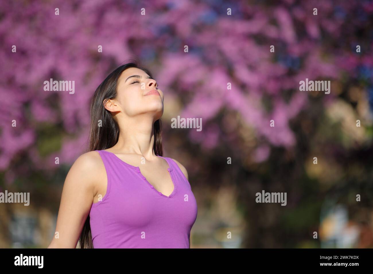 Woman in violet shirt breathing fresh air in a garden Stock Photo - Alamy