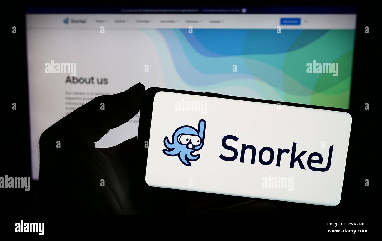 Person holding smartphone with logo of US artificial intelligence company Snorkel AI Inc. in front of website. Focus on phone display. Stock Photo