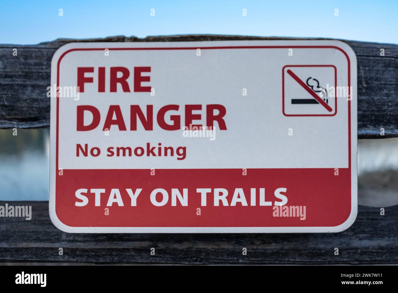 Forest fire warning sign board. Extreme Fire Danger Sign in the park. Sign forbidding bonfires. Danger of forest fires. Burning grass. A red sign It i Stock Photo
