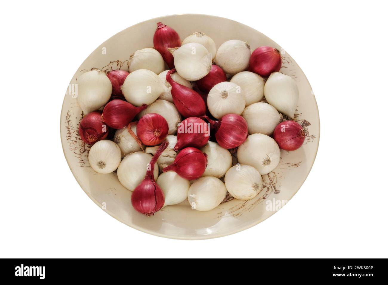 Onion in a ceramic plate isolated on white background. Salad purple and white onion in village bowl. Harvest. Stock Photo