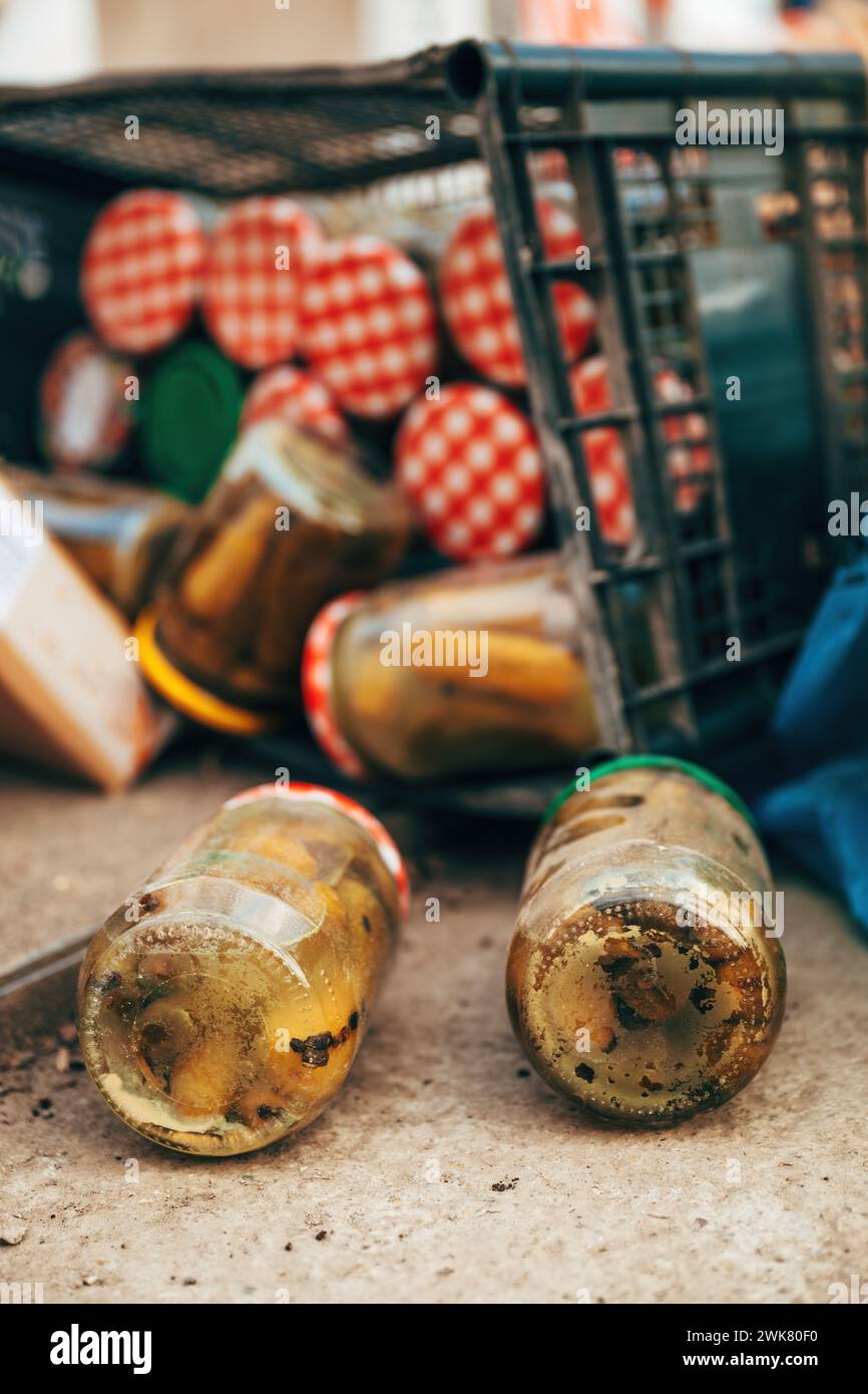 Expired homemade pickled cucumbers in jar thrown away, selective focus Stock Photo