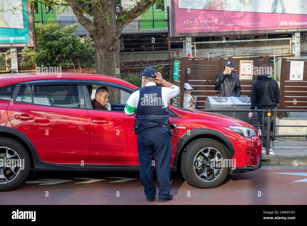 Japanese Policeman speaks to a driver in his car, Harajuku ward,Tokyo,Japan,Asia,2023 Stock Photo