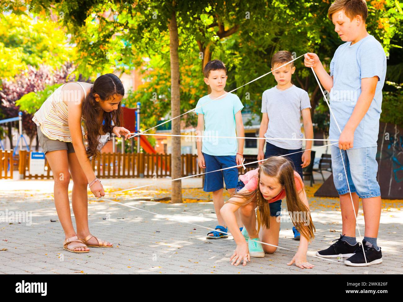 children games. Girl goes through the tangled rope Stock Photo - Alamy