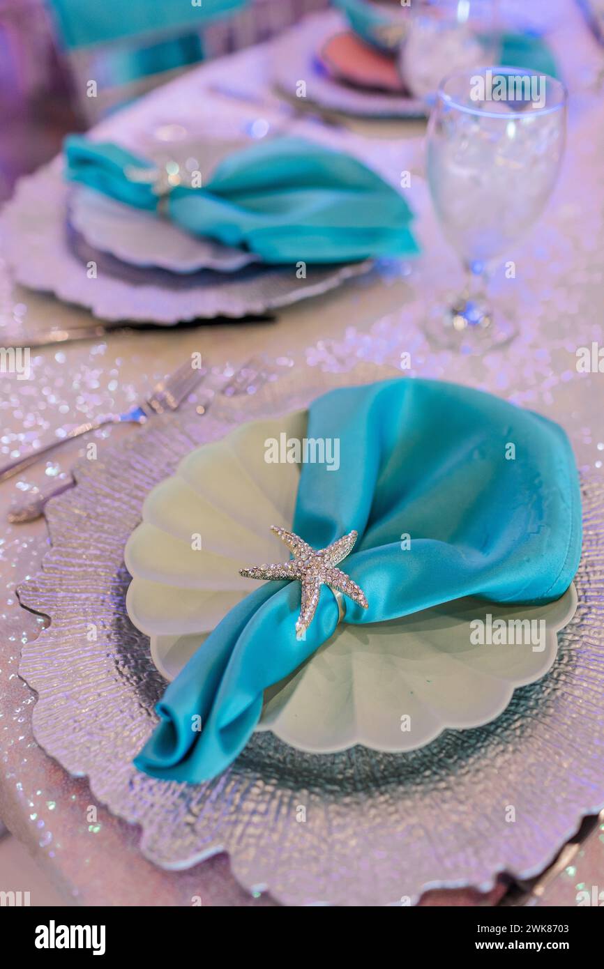 Teal napkins with glittery starfish napkin ring as table setting Stock Photo