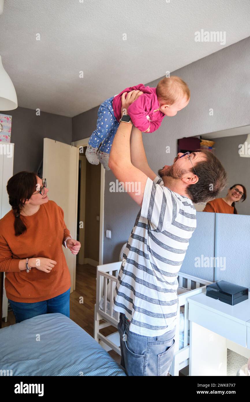 Happy parents playing with their 6-Month-Old baby girl at home. Stock Photo