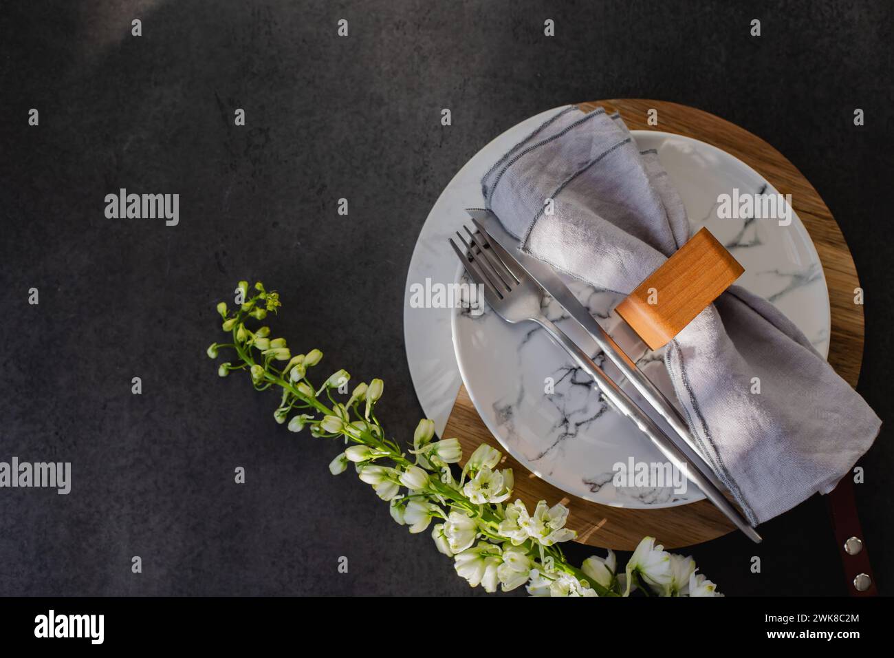 Easter table setting concept. Plate, easter eggs, cutlery and spring flower on dark background table Stock Photo