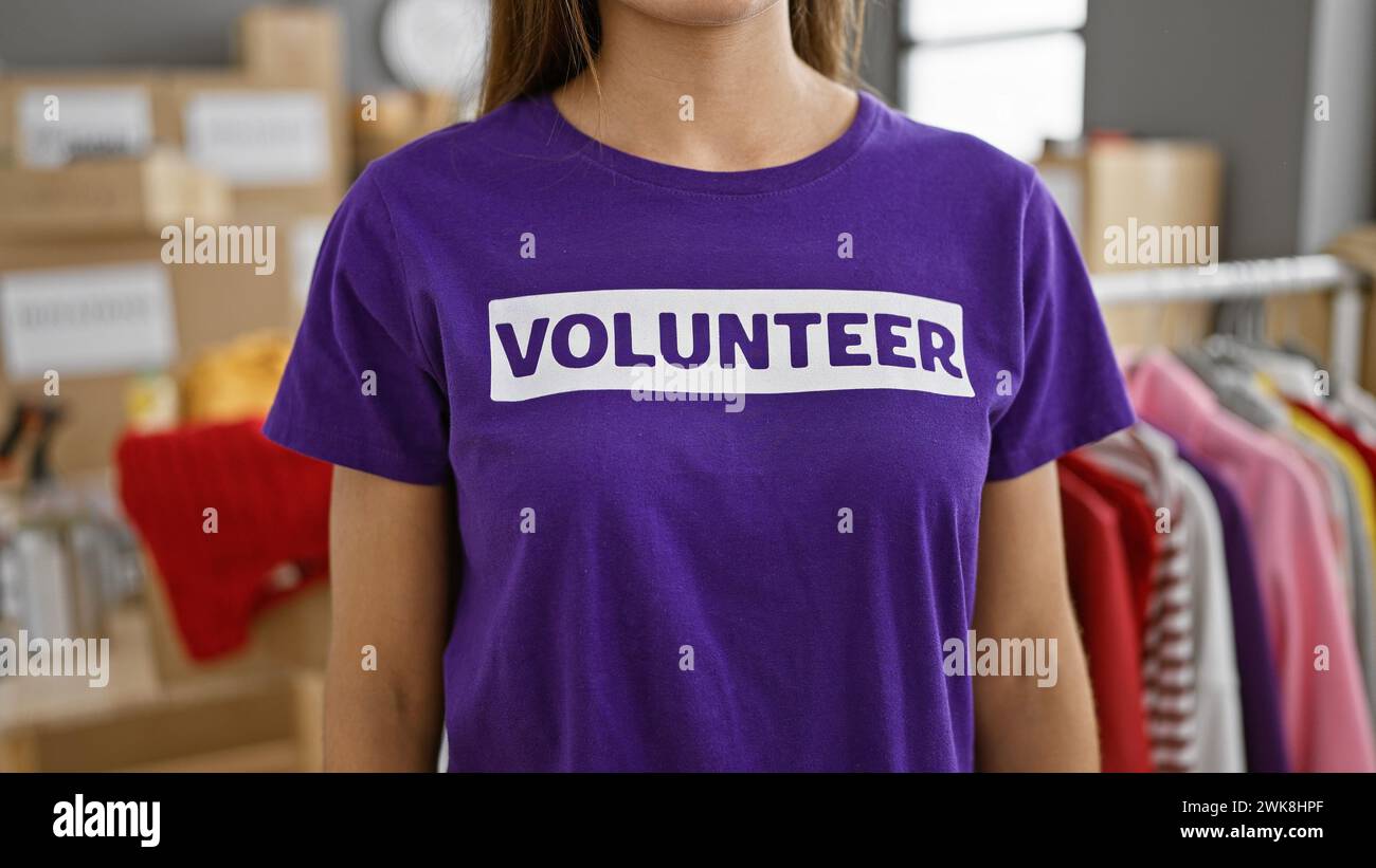 Hardworking hands of a dedicated hispanic woman volunteer, standing with unity and altruism at heart in the bustling charity center room, providing so Stock Photo
