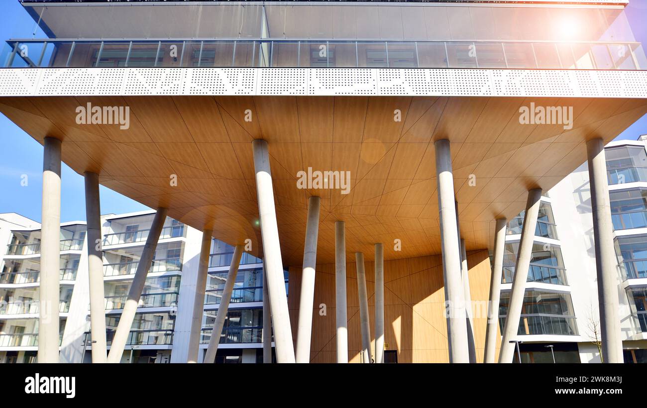 A apartment building with a unique architectural solution. A modern residential building with a white facade and standing on high concrete pillars. Stock Photo