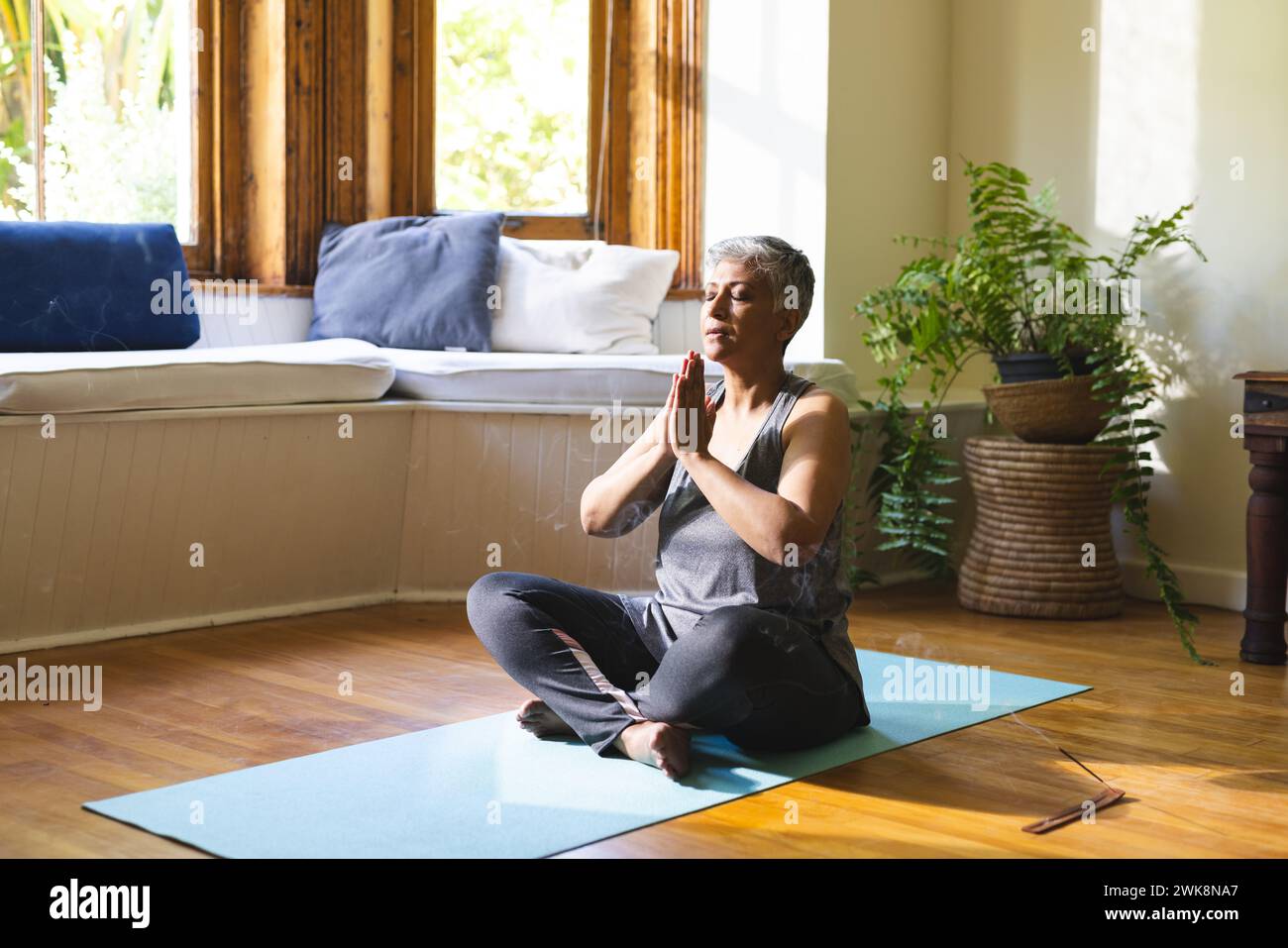 A mature biracial woman practices yoga at home Stock Photo