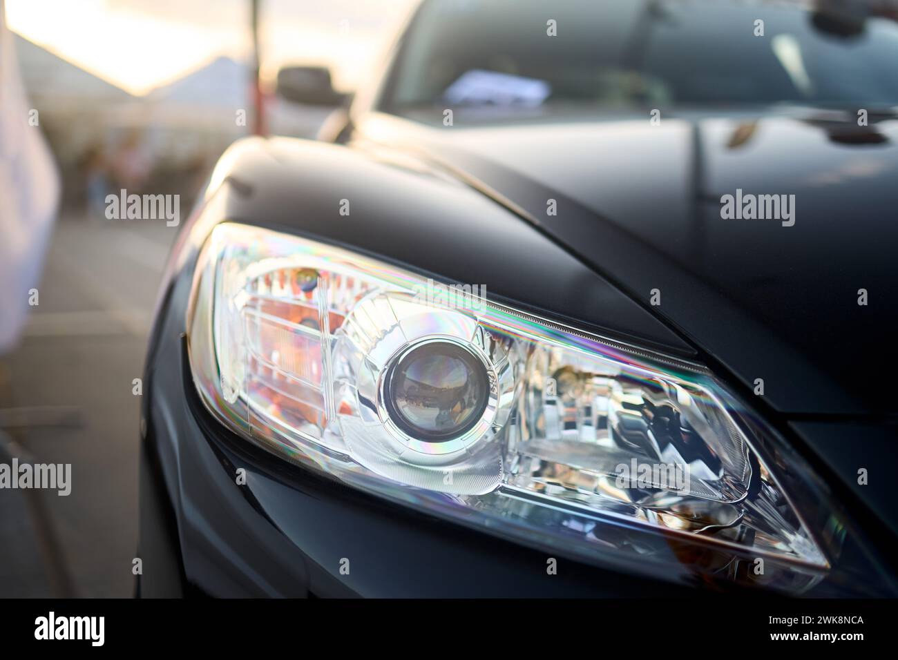 Berlin, Germany - August 20, 2022: Car Detail Shot of Mazda RX-8. Headlight front of black metallic car shot closeup on out of focus background with Stock Photo