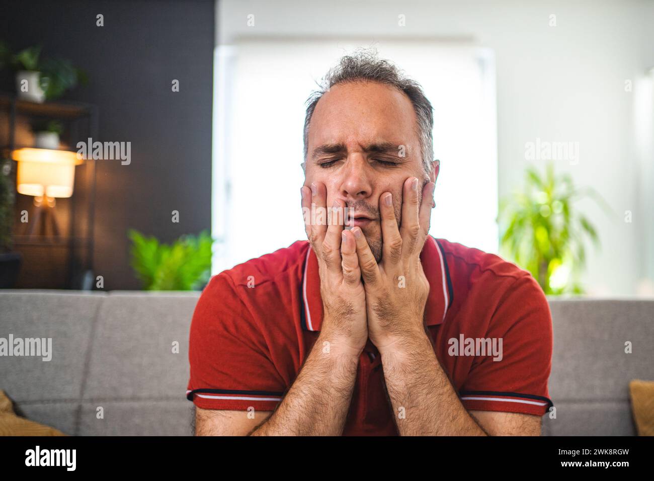 Man sitting alone at home looking sad and distraught Stock Photo - Alamy