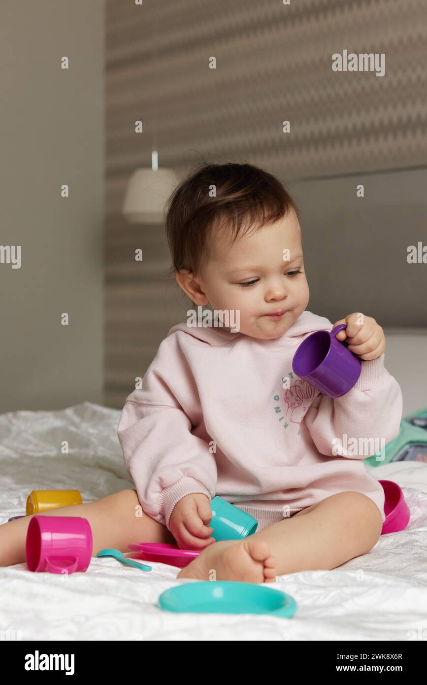 happy cute little child girl playing and pretending drinking tea from ...