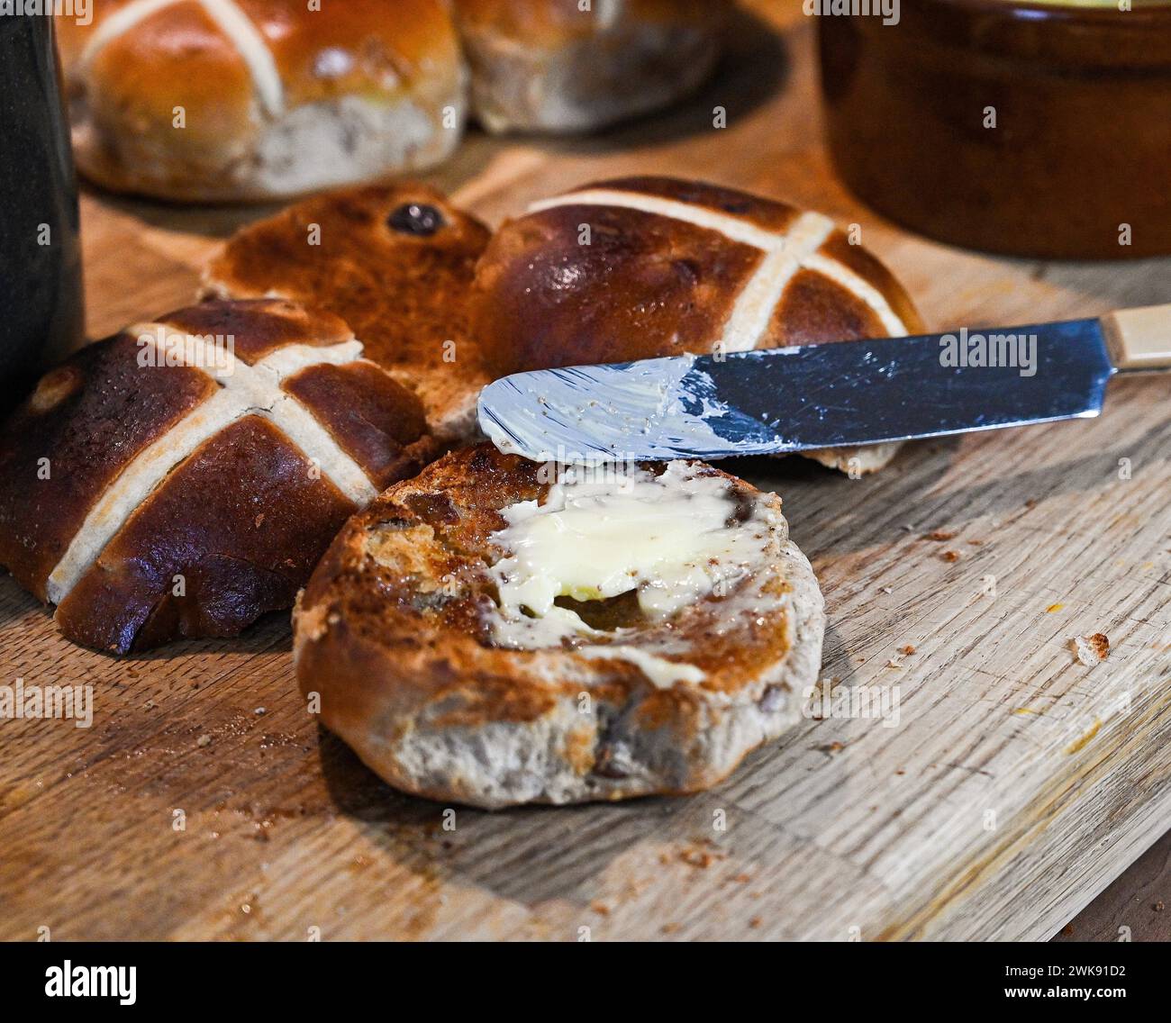 Toasted Hot Cross Buns with butter a traditional breakfast food eaten at Easter Stock Photo