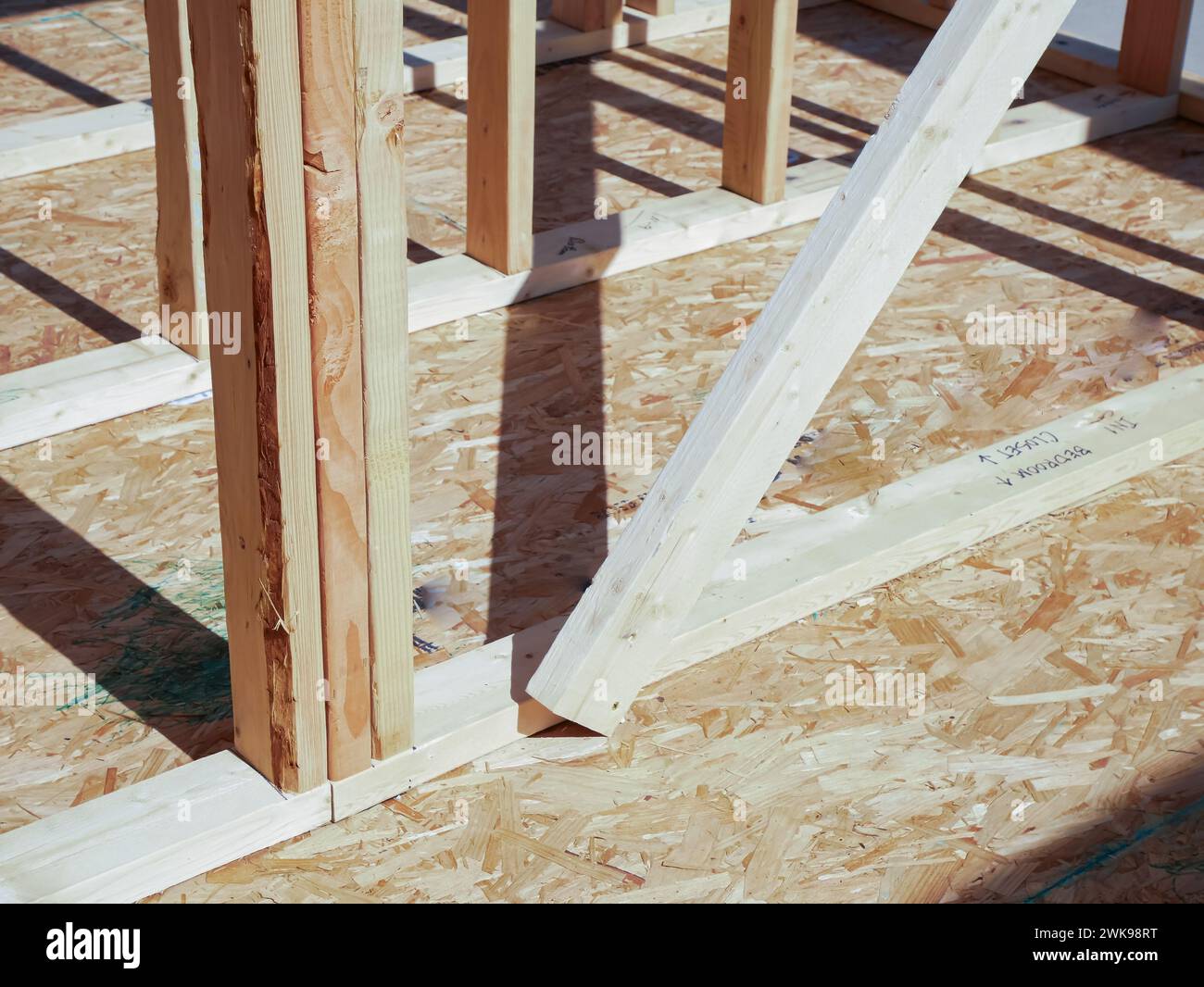 OSB sub flooring sheets cover, attach to the joists with wood screws Oriented Strand Board plywood, timber framing with posts beams studs of new house Stock Photo