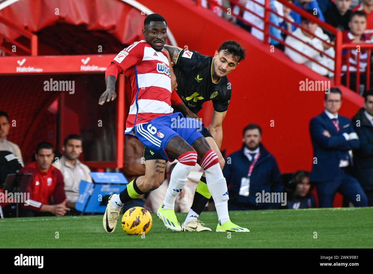 Granada, Granada, Spain. 18th Feb, 2024. Martin Hongla of Granada CF competes for the ball with Lucas Robertone of UD AlmerÃ-a during the Liga match between Granada CF - UD AlmerÃ-a at Nuevo Los CÃrmenes Stadium on February 18, 2024 in Granada, Spain. (Credit Image: © José M Baldomero/Pacific Press via ZUMA Press Wire) EDITORIAL USAGE ONLY! Not for Commercial USAGE! Stock Photo